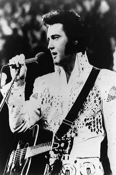 Aloha from Hawaii: Elvis Presley mit einem seiner berühmten Jumpsuits und Haartolle. Bild: dpa Bilderdienste